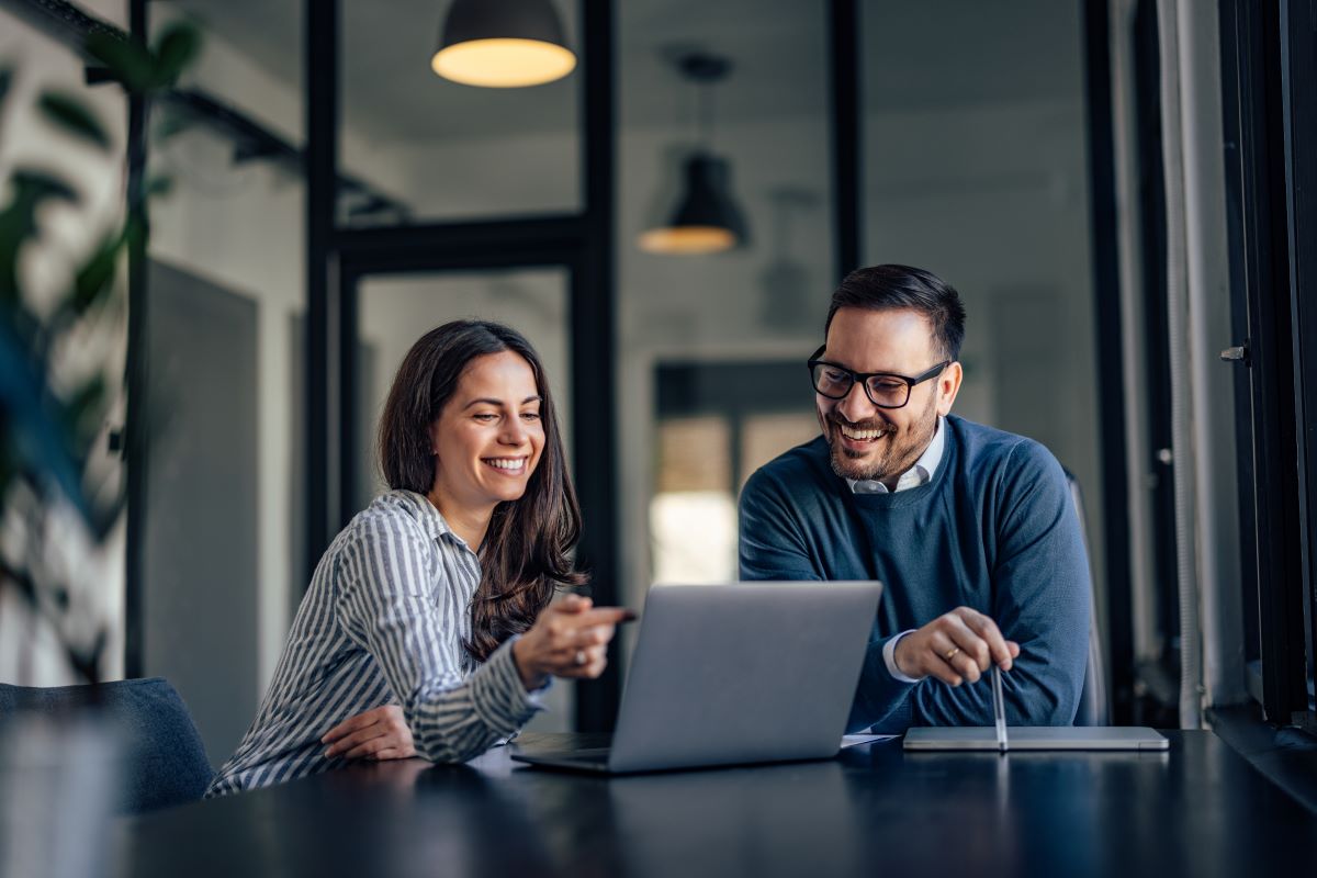 Woman and man smiling looking at the laptop